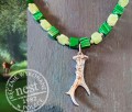 Srebrzona zawieszka w kształcie poroża kozła na naszyjniku z zielonych kamieni