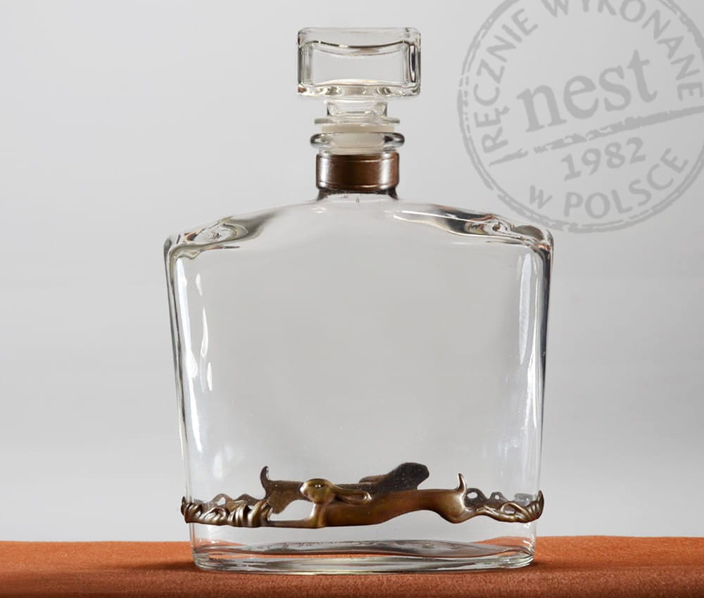 Szklana karafka z aplikacją zająców z brązu